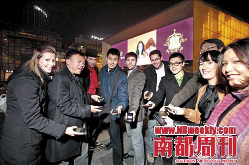 　　在北京三里屯的 苹果专卖店前，4SQ玩家们正在享受一场“签到北京”活动的乐趣。摄影 贾树森